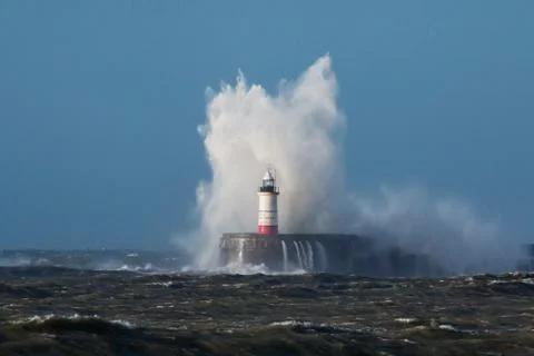 Breaking wave over Newhaven Lighthouse. Stock Photos