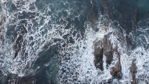 Breaking wave over rocks Video stock 106425835