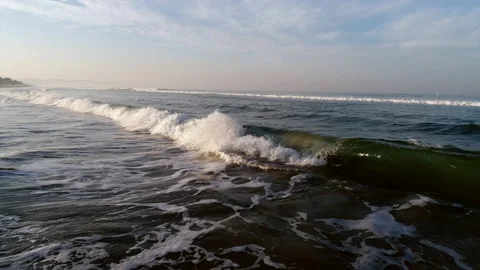 The breaking wave rolls beautifully on the sandy beach and breaks with foam  Stock Footage 168496808
