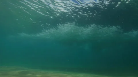 Breaking Wave Sends White Bubbles Through Turquoise Water Above Seabed Stock Footage 344033861