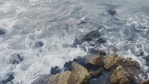 Breaking waves against rocks-slow motion Stockbeeldmateriaal 220874412