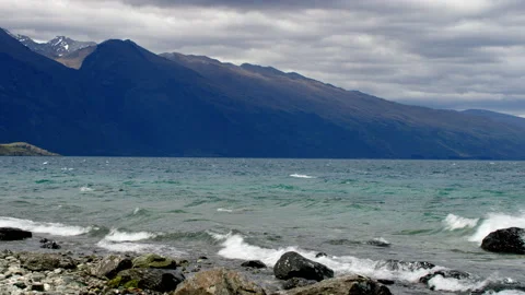 Breaking waves on alpine lake with hills and mountains Stock Footage 159747510