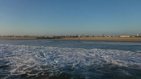 Breaking waves approaching Huntington Beach shoreline in warm light Stock Footage 346317539