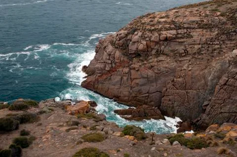 Breaking waves at bottom of cliff Foto stock