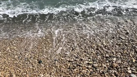 Breaking waves on sandy and small stoned beach Stock Footage 142481074