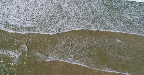 Breaking waves on shore rotate by drone 4K Stock Footage 74943489