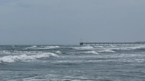 Breaking white waves in a rough sea with a view over the ocean and pier. Stock Footage 101842823