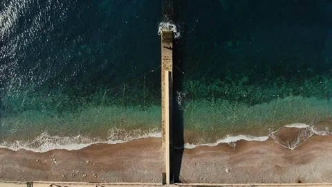 Breakwater on beachfront with turquoise ocean water horizontal aerial view Stock Footage 104255151