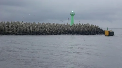 Breakwater boulders with seagulls and sea beacon Stock Footage