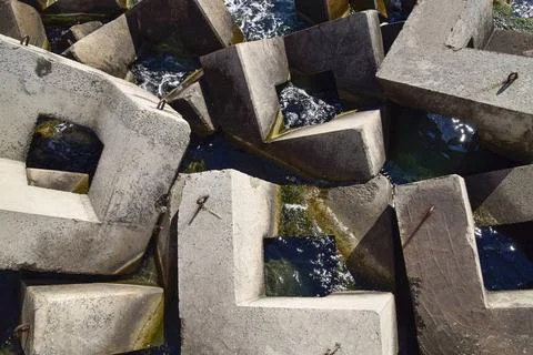 Breakwater of the rectangular stone figures. Breakwater blocks in the port... 库存照片