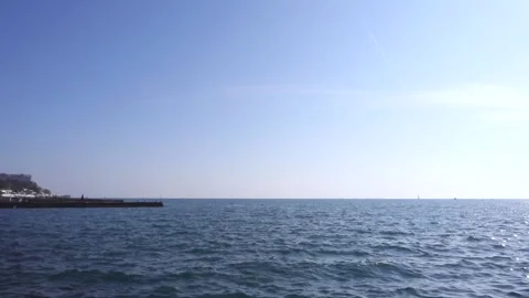 Breakwater, the setting sun in a cloudless sky glitters in the waves. Stock Footage 179541106