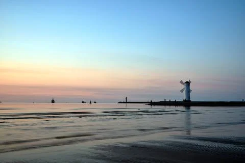 A breakwater with a watermark in the shape of a windmill Stock Photos