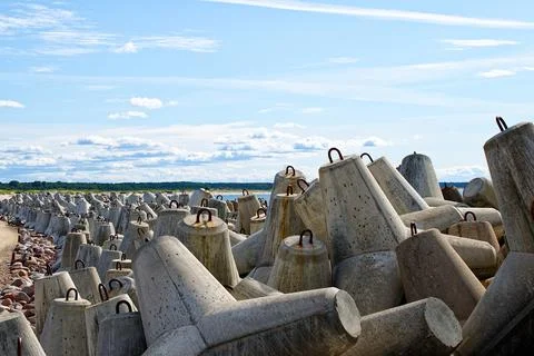 Breakwaters are concrete figured structures. The road to the lighthouse in Ve Stock Photos