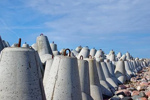 Breakwaters are concrete figured structures. The road to the lighthouse in Ve Stock Photos