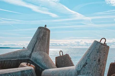 Breakwaters are concrete figured structures. The road to the lighthouse in Ve Stock Photos