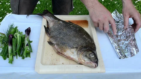 Bream fish prepared for bake in fire bonfire ember cinder foil Stock Footage 22453067