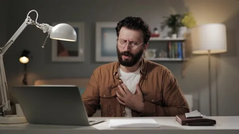 Breathing problems. Bearded middle-aged man at computer with panic attack 스톡 동영상 196201988