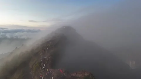 A breathtaking 4K drone shot of a mist-covered hill summit in Bali, where h.. Stock Footage 299434584