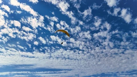 A breathtaking aerial drone video captures a paraglider soaring gracefully Stock Footage 283344018