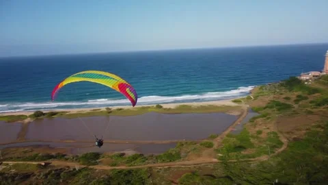 A breathtaking aerial perspective captures a paraglider soaring over Stock Footage 277443734