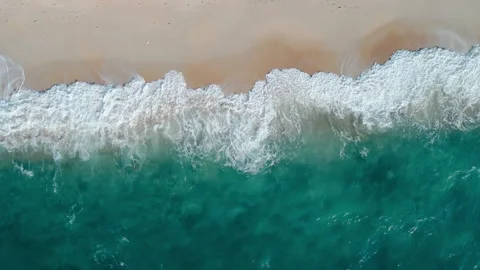 Breathtaking aerial sweep capturing waves meeting golden shore, waves rolling Stock Footage 312123150