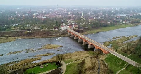 A breathtaking Aerial View of the Bridge Over the Serene River showcasing its Stock Footage 309518404