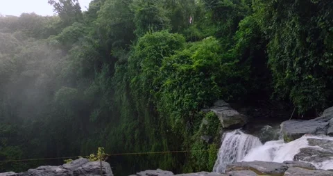 Breathtaking aerial view of a lush waterfall in a forest Stock Footage 274298027