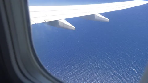 Breathtaking Aerial View of the Ocean Below Through an Airplane Window in 4.. Stock Footage 260233772