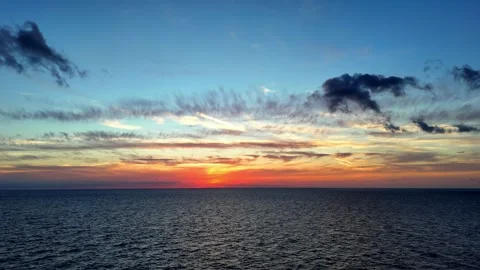 Breathtaking aerial wide angle view of vibrant golden sunset over calm 스톡 동영상 331109899