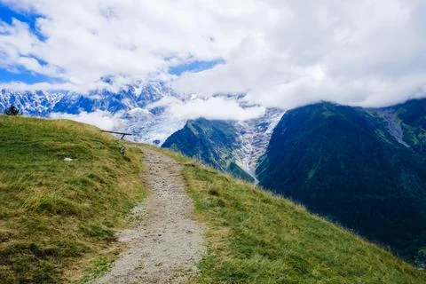 Breathtaking alpine path with stunning mountain views in the background on .. Stock Photos