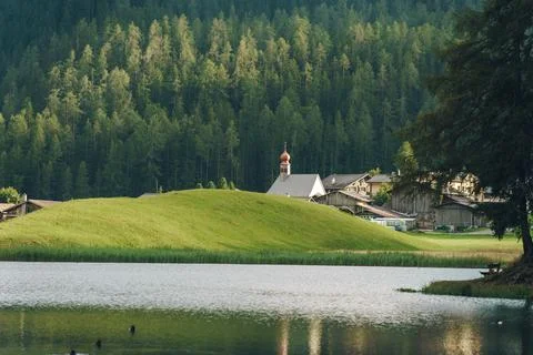 Breathtaking alpine scenery featuring a picturesque village nestled by a serene Stock Photos