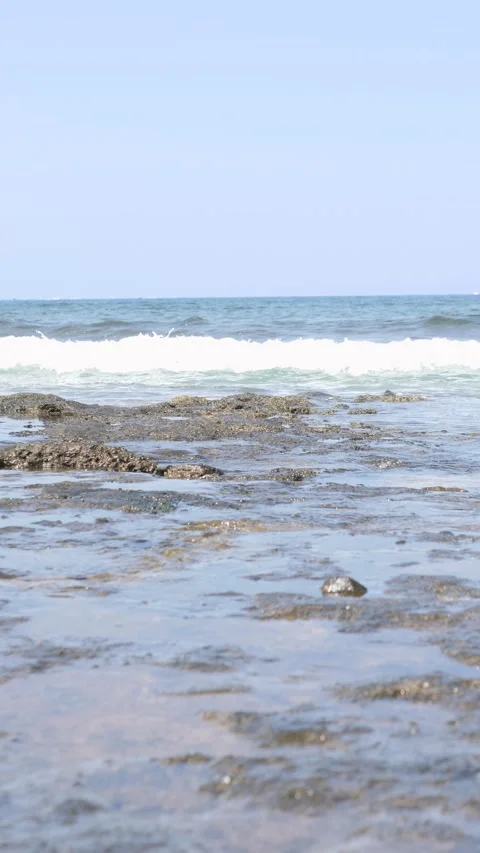 Breathtaking and Serene Beachfront Views with Gentle Waves Lapping at Rocky Stock Footage 318620653