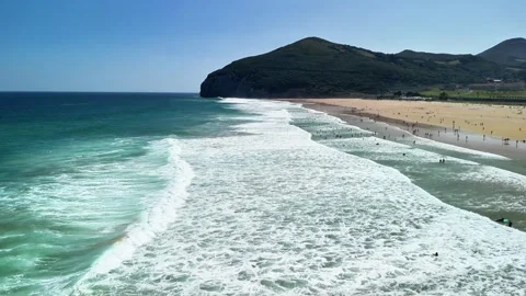 A breathtaking beach landscape featuring beautiful waves and numerous visitors Stock Footage 308404890