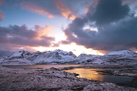 Breathtaking blaze of the setting sun over the fjords and snow-covered moun.. Stock-Fotos