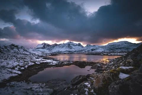 Breathtaking blaze of the setting sun over the fjords and snow-covered moun.. Stock-Fotos
