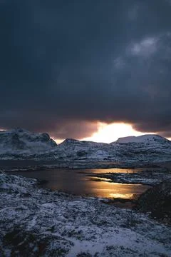 Breathtaking blaze of the setting sun over the fjords and snow-covered moun.. Stock-Fotos