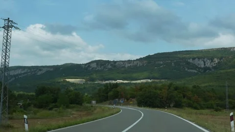 Breathtaking car windshield view of winding road leading towards mountains Stock Footage 299894820
