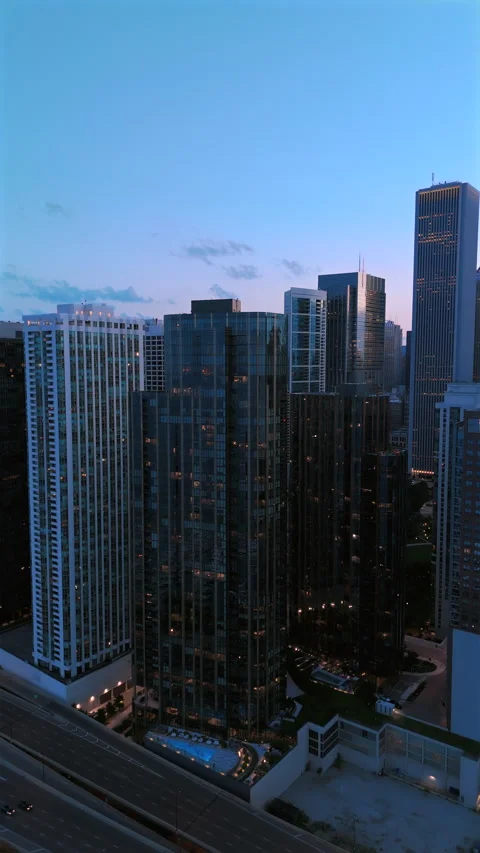 A breathtaking cityscape view at dusk featuring modern skyscrapers and their Stock Footage 315320118