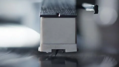 Breathtaking close-up of the needle of a record player being manually placed on Видео 327515018