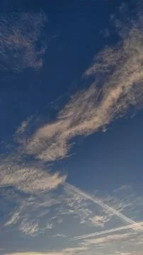 Breathtaking clouds drift across a clear blue sky at dawn Stock Photos