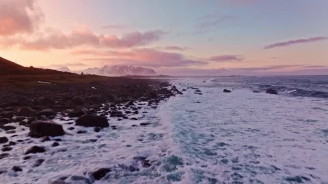 A breathtaking coastal sunset showcasing the waves and rocky shoreline Stock Footage 303703999