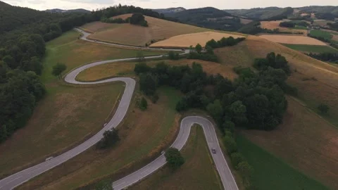 A breathtaking drone view of a winding mountain road with multiple hairpin Stock Footage 339381115
