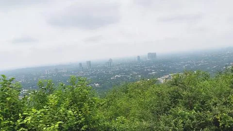 Breathtaking high angle cityscape view surrounded by green lush forest Stock Photos
