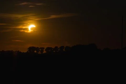 A breathtaking horizontal landscape of a partial solar eclipse glowing in a d Stock Photos
