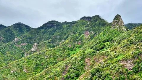 A Breathtaking Lush Green Mountain Range Nestled Beneath a Dramatic Overcast Stock Photos