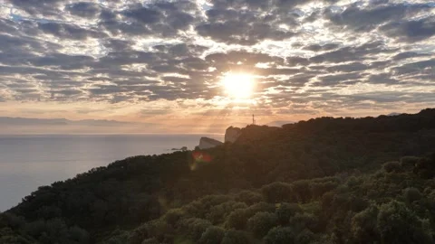 Breathtaking morning sun shining through patterned clouds over Cape Drastis Stock Footage 334214014
