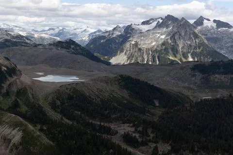 Breathtaking mountain range with expansive valleys and serene lake on a clo.. Stock Photos