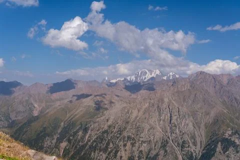 Breathtaking Mountain Range Under a Clear Blue Sky with Fluffy Clouds Captu.. 写真素材