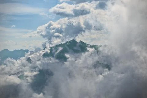 Breathtaking mountain surrounded by clouds Stock Photos