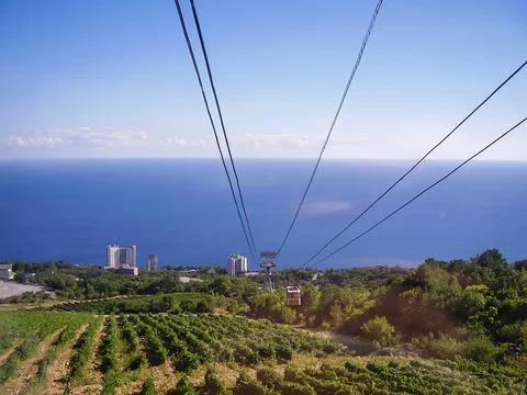 Breathtaking mountain views: Cable car ascends a lush hillside, with a panoramic Stock Photos
